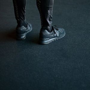 Close up of an athletic shoe on a dark floor, symbolizing a stable base.